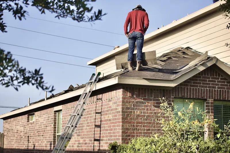 Professional roofer working on a residential roof in Dennis Port